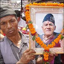 Man with portrait of deceased - via Daymix