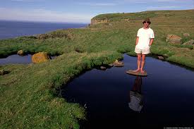 Man on a stone in a pond. - via Daymix