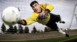 A goalkeeper dives - via Daymix