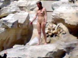      a  woman stripping   off for a dip    